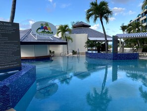 Zona de piscina con un letrero que dice 'Cabana Beach Bar & Restaurant' y un puesto de salvavidas.