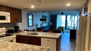 A modern kitchen with granite countertops, a built-in microwave, and a dishwasher. - Beachfront, ground level condo, steps away from beach, pool and relaxation! (Cole Bay)