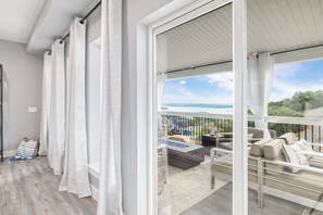 A balcony with a view of a lake, a seating area with cushions, and a wooden floor. - Large-group Retreat w/Hot Tub, 2 Kitchens, Grill (Branson)