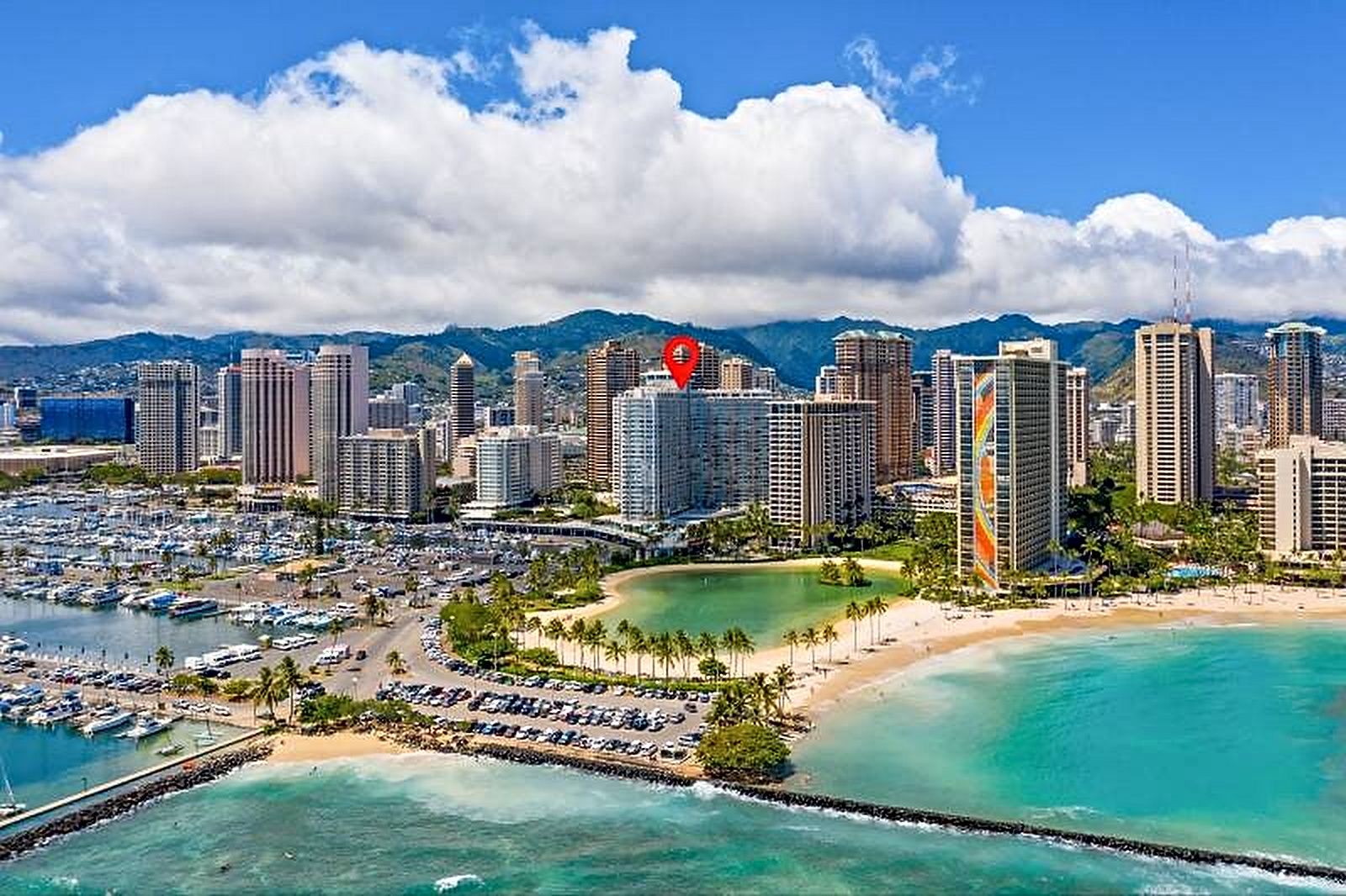 A coastal cityscape with high-rise buildings, a marina, and a beach.