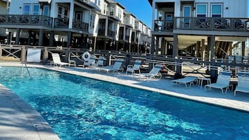 A poolside view of Sunset Cottage with a clear blue sky.