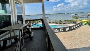 A balcony with a view of a lake, a pool, and dock areas. - Flash Sale~Book Now~Tortuga Daybreak~Sleeps 8 (Gulf Shores)