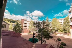 A courtyard with buildings, trees, and a clear blue sky. - Silver Mill 8189 (Keystone)
