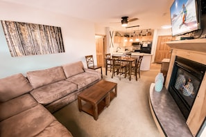 A living room with a sofa, coffee table, fireplace, and TV. - Silver Mill 8189 (Keystone)