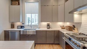 A modern kitchen with stainless steel appliances, a dishwasher, and a window providing natural light.