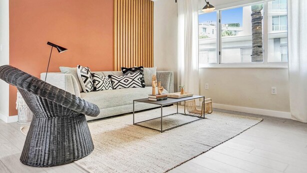 A modern living room with a sofa, a coffee table, and a wicker chair. - Terracotta Suite 2BD/2BA Miami Beach Lincoln Suite (Miami Beach)