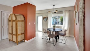 A dining area with a round table and four chairs, a ceiling light fixture, and a view through a window. - Terracotta Suite 2BD/2BA Miami Beach Lincoln Suite (Miami Beach)