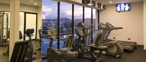 A gym with treadmills, stationary bikes, and weight machines.