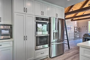 A modern kitchen with stainless steel appliances, white cabinetry, and a wooden ceiling. - Airy Alpine Getaway w/ Lake Arrowhead Views! (Lake Arrowhead)