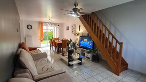 A living room with a sofa, TV, and staircase. - Lovely house with private parking/covered terrace close to beaches and amenities. (Douarnenez)