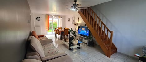 A living room with a sofa, TV, and staircase.