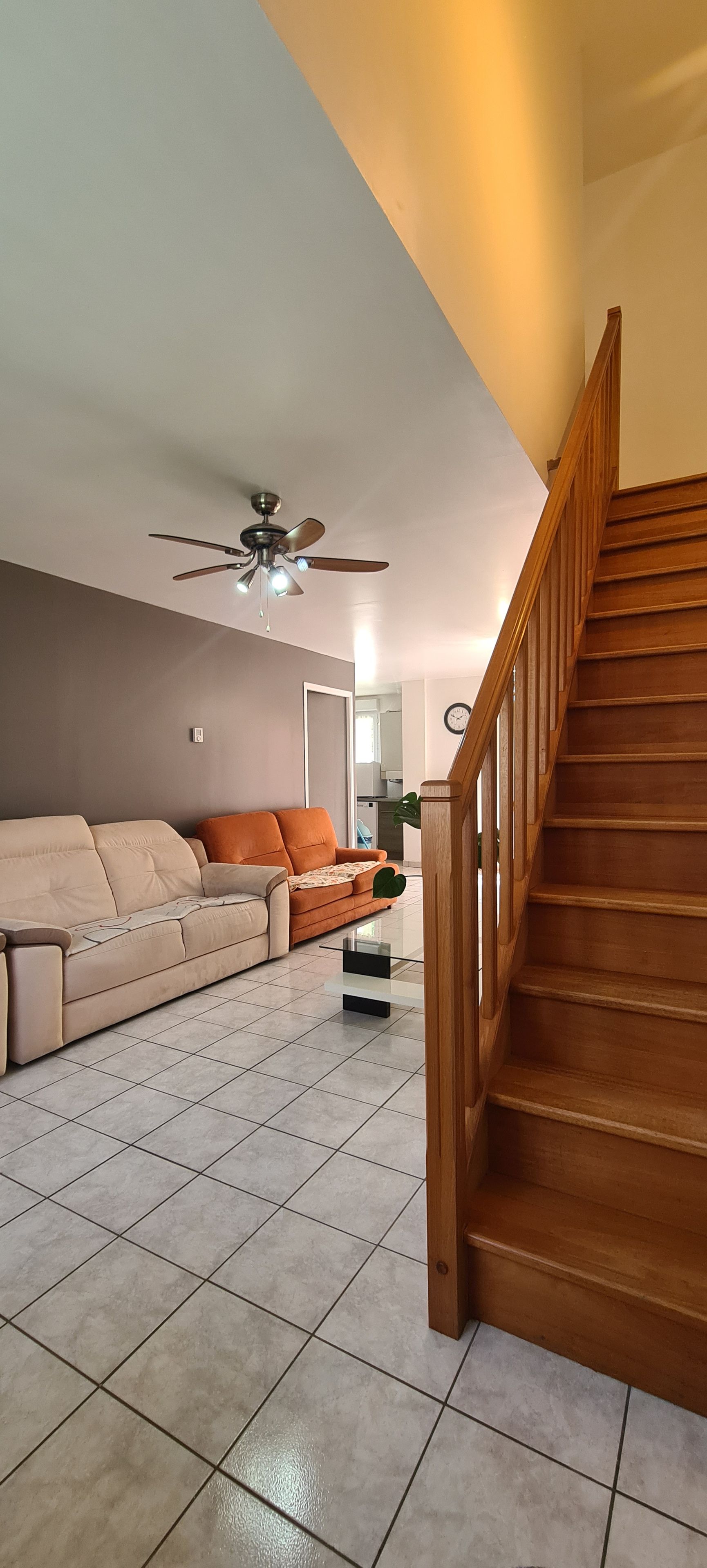 A living room with a sofa, a coffee table, and a staircase.