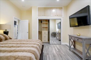 Relax in this serene bedroom with a large bed, TV, and convenient closet.