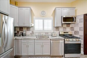 Enjoy cooking in this well-equipped kitchen with a central island, sink, and microwave.
