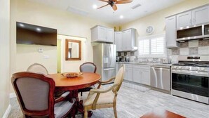 A modern kitchen with a dining area, stainless steel appliances, and a ceiling fan. - Furnished Cottage, Los Angeles California (Los Angeles)