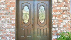 A double wooden door with glass panels and a metal handle, set in a brick wall. - Furnished Cottage, Los Angeles California (Los Angeles)