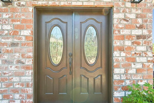 A double wooden door with glass panels and a metal handle, set in a brick wall. - Furnished Cottage, Los Angeles California (Los Angeles)