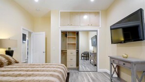 A bedroom with a bed, a wardrobe, a TV, and a desk. - Furnished Cottage, Los Angeles California (Los Angeles)