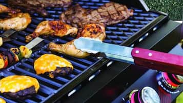 A grill with various meats and vegetables being cooked.