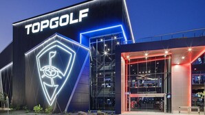 A modern building with a prominent 'TOPGOLF' sign and a distinctive illuminated logo. - Luxury 3-Bedroom Home with Pool Near Stadium-Perfect for Game Weekends (Glendale)