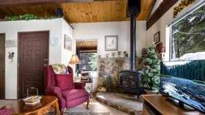 A cozy living room with a fireplace, a comfortable armchair, and a television.