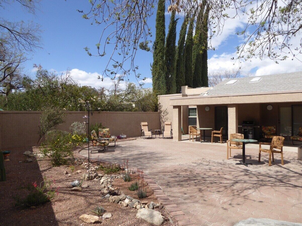 A patio area with outdoor seating, a covered section, and a landscaped garden.