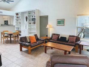 A living room with a sofa set, a coffee table, and a dining area with chairs and a table.