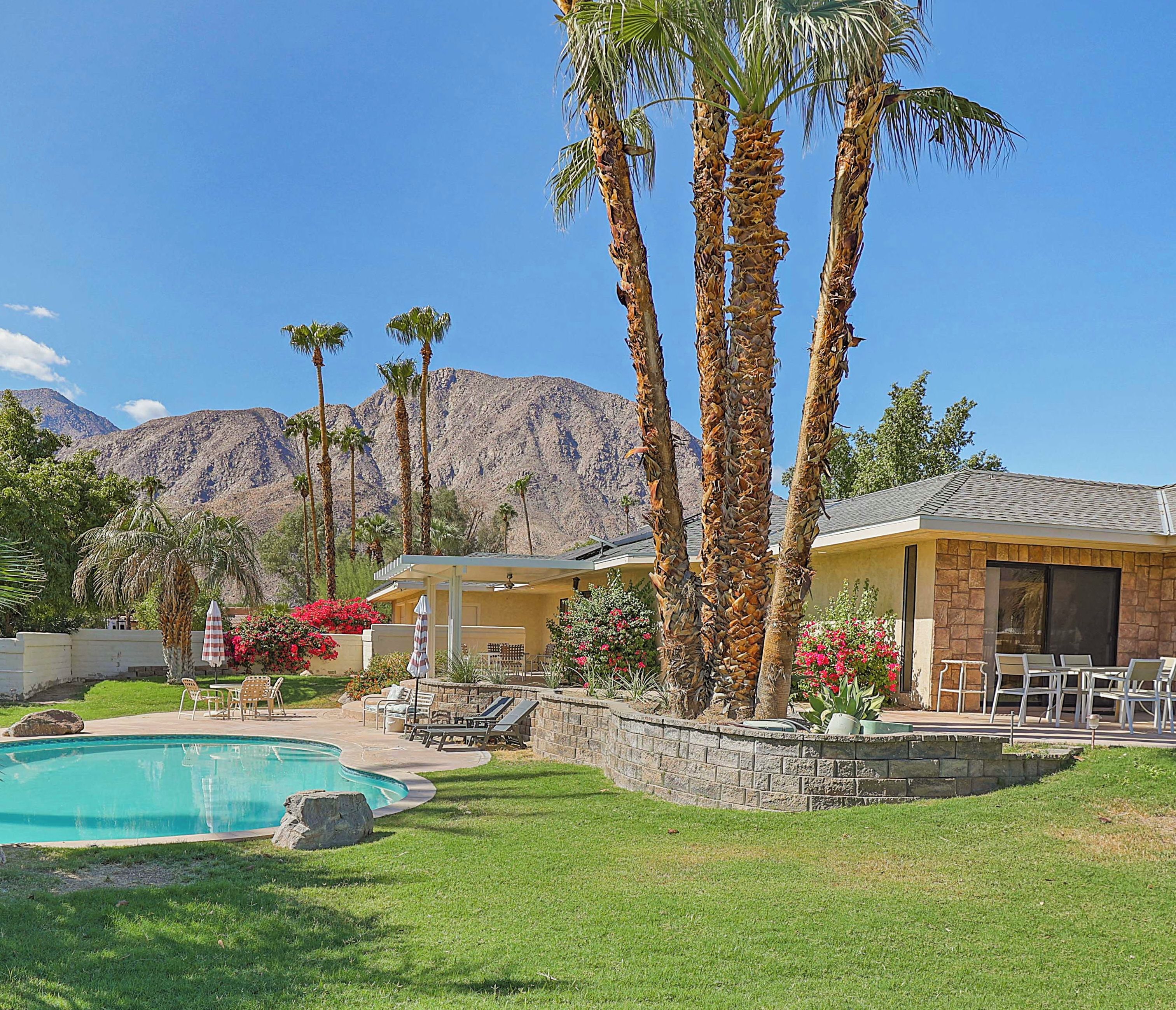 Backyard with pool with multiple patios and seating/dining areas.  