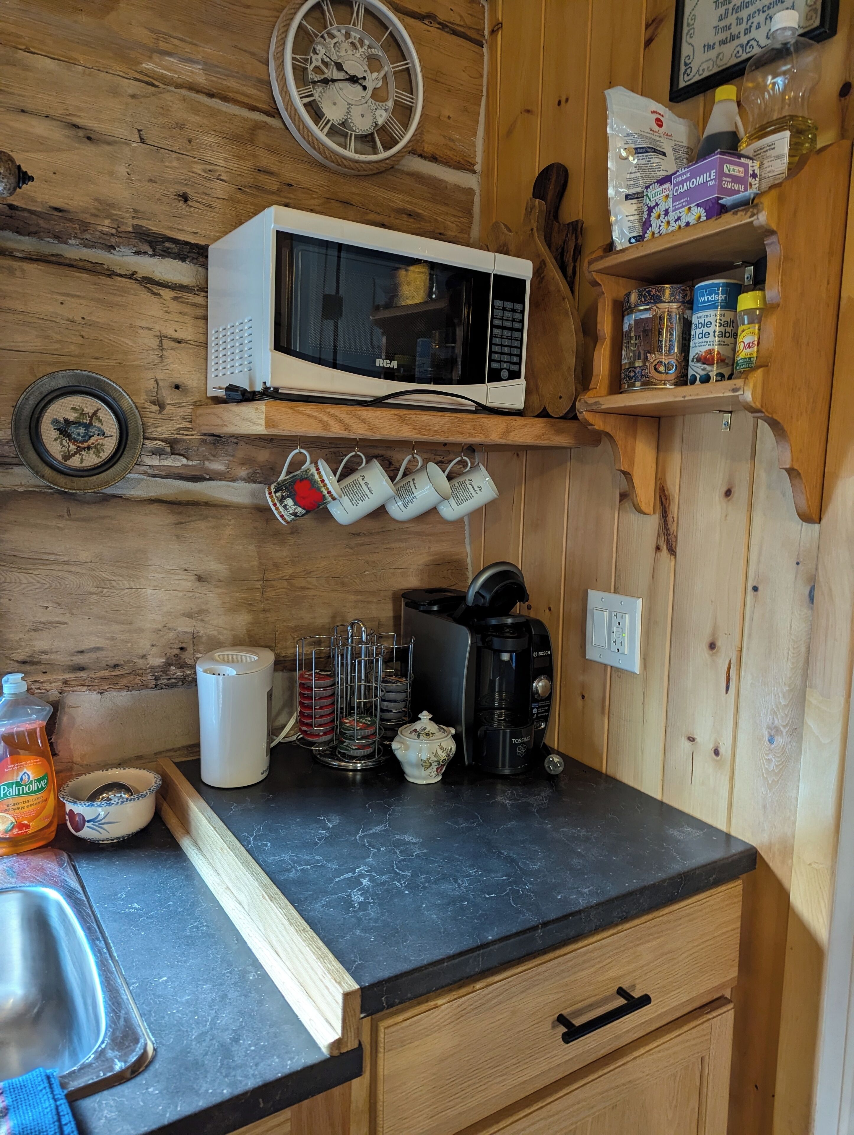 Una cocina compacta equipada con microondas, cafetera y diferentes utensilios de cocina.