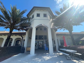 A building with a central entrance, columns, and a tiled roof.