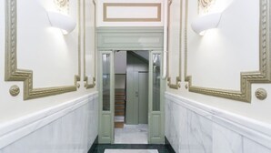 A hallway with marble flooring, a staircase, and decorative wall moldings. - vip  LETRAS, by MONARO***** (Madrid)