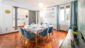 A dining area with a table set for four, wooden flooring, and a view of a cityscape through large windows. - vip  LETRAS, by MONARO***** (Madrid)