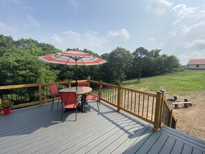 A wooden deck with a table and chairs, an umbrella, and a railing. - Simply Buffalo sleeps 10,  St Joe, AR- Float the middle beautiful Buffalo River (Saint Joe)