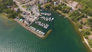 An aerial view of a marina with docks and boats, surrounded by residential buildings and greenery. - Gorgeous Waterfront home with sweeping views of a beautiful bay. (Bath)