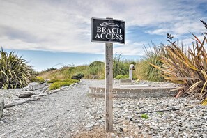 Señal de acceso a la playa con un sendero que lleva a ella.