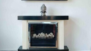 A modern living room with a flat-screen TV mounted on the wall above a fireplace. - The OVO Hydro Penthouse With Free Parking (Glasgow)