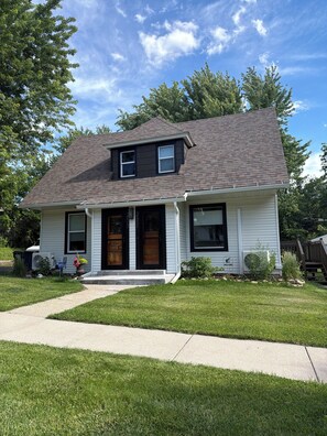 A two-story house with a front porch, a garage, and a well-maintained lawn. - Historic downtown flat (Owatonna)