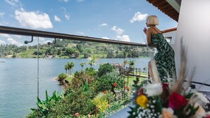 A balcony with a view of a lake and greenery. - Jordan Hotel Boutique (El Peñol)