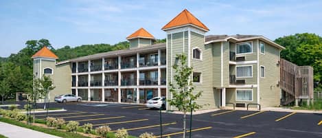 A multi-story hotel with a parking lot and a small garden area.