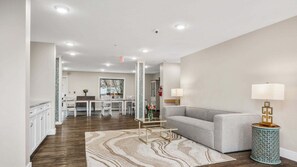 A modern living room with a sofa, a coffee table, and a patterned rug. - 🏖️ Gold Coast Inn | Breathtaking Lake Views • Corner Rm 208 (Traverse City)
