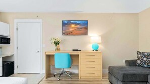 Een hotelkamer met een bureau, stoel en een bed.