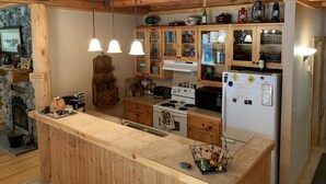 Una cocina rústica con armarios de madera, una isla central y lámparas colgantes.