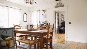 A dining area with a wooden table and chairs, a chandelier, and a rug. - Nemo Farmhouse on Centennial Trail With a View (Nemo)
