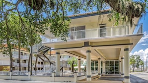 A two-story building with a balcony, a staircase, and a covered entrance area. - Rodeway Inn Central Clearwater Beach (Clearwater)