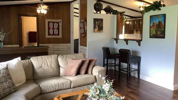 A cozy living room with a leather sofa, a glass coffee table, and a dining area with a small table and chairs. - Neat Retreat, Fast WiFi, Ski Sipapu, Hike, Fish, Hunt,
Wineries, pet friendly  (Penasco)