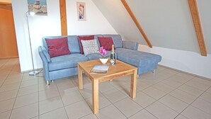 A cozy living room with a blue sofa, a wooden coffee table, and a small decorative bowl.