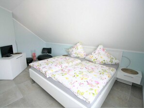 Une chambre à coucher avec un lit, une télévision, un bureau et une chaise.