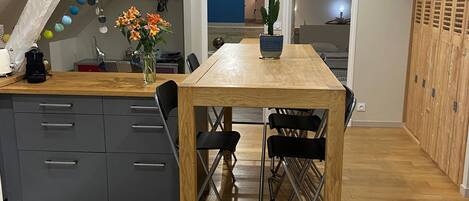 Una cocina moderna con una mesa de madera, armarios grises y un suelo estampado.