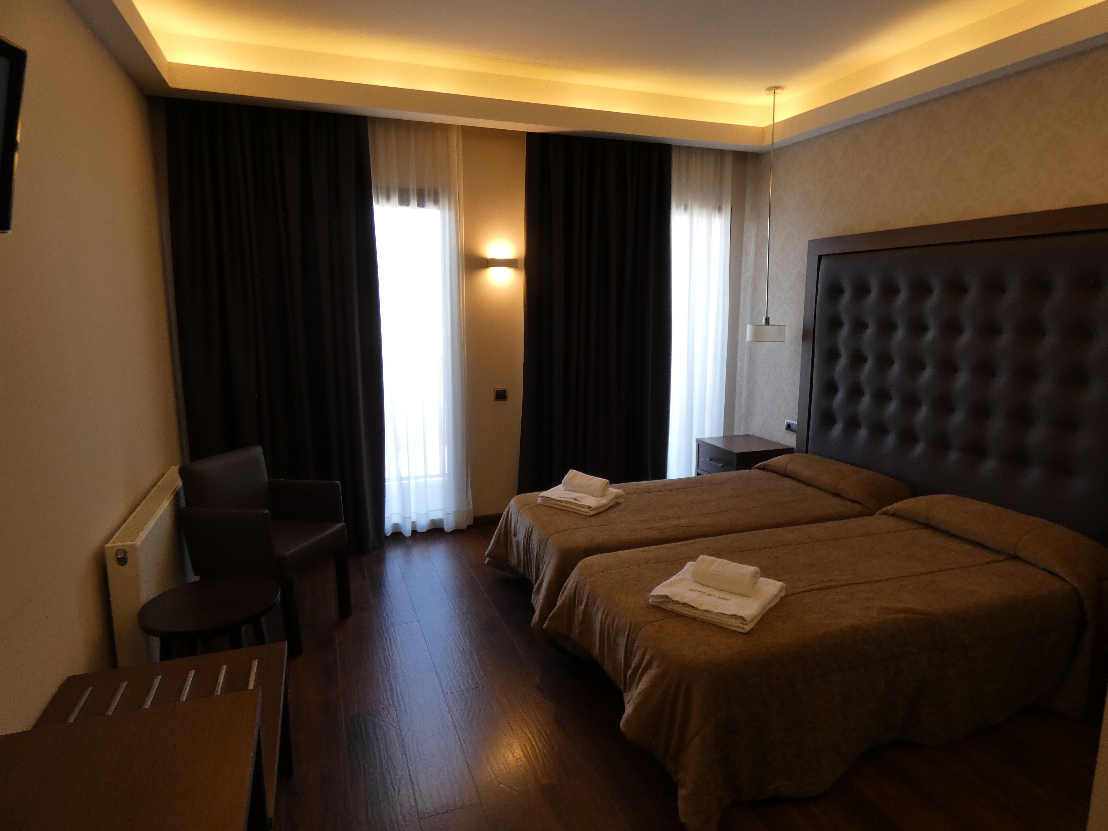 Une chambre d’hôtel avec un lit double, un bureau et une chaise.