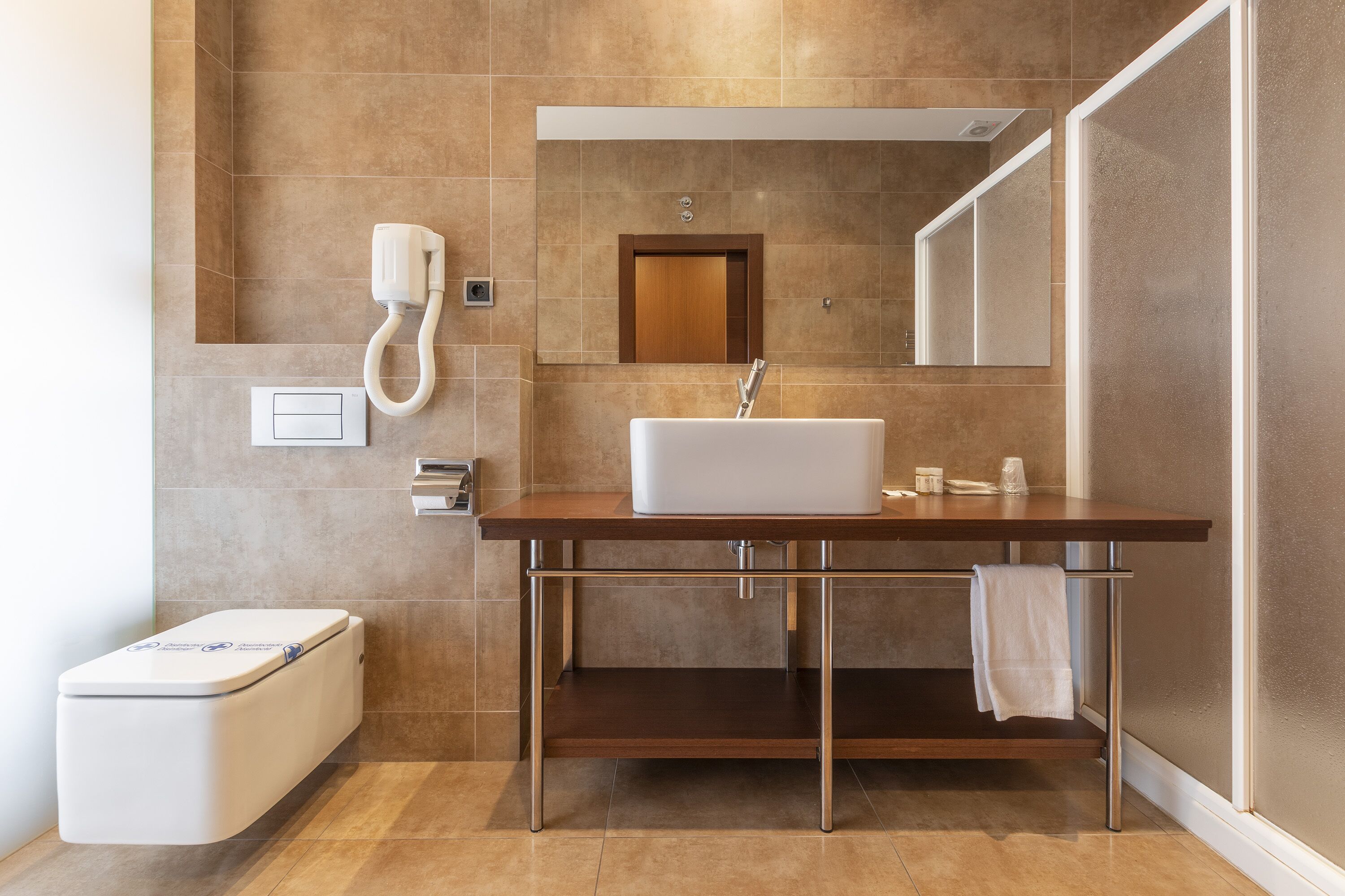 Een regendouche, een haardroger, een bidet, handdoeken